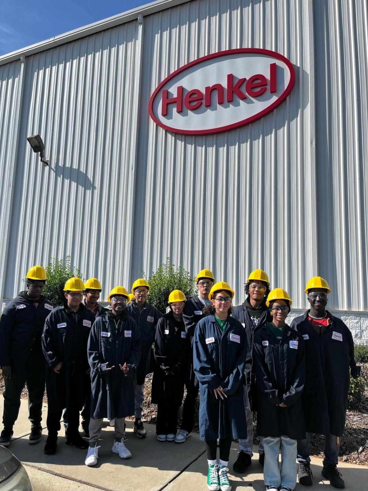 A group of staff and kids outside a Henkel building.