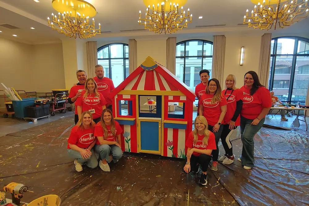 A group surrounding a finished playhouse.