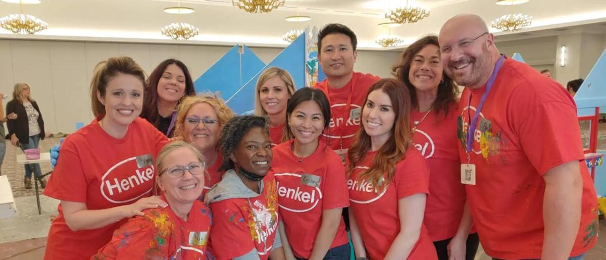 A group of people huddled for the photo. Wearing matching Henkel t-shirts.