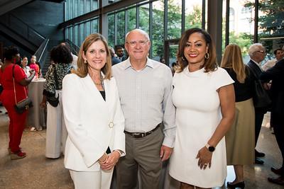 Three people dressed in white at the museum opening.