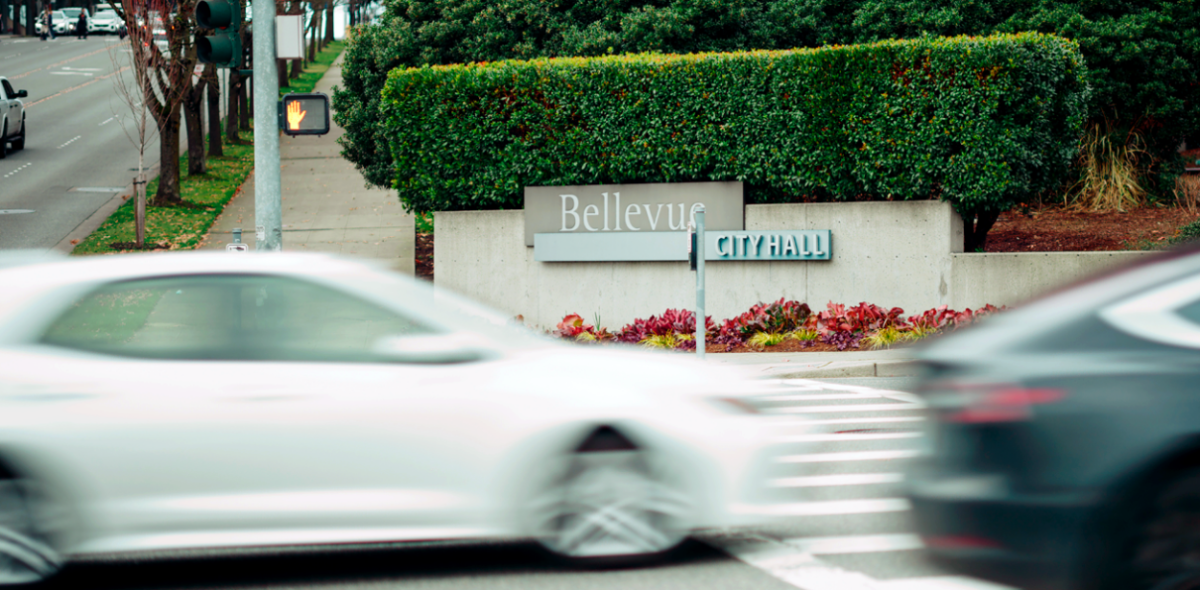 Cars going by on a street in front of a sign "Bellevue"