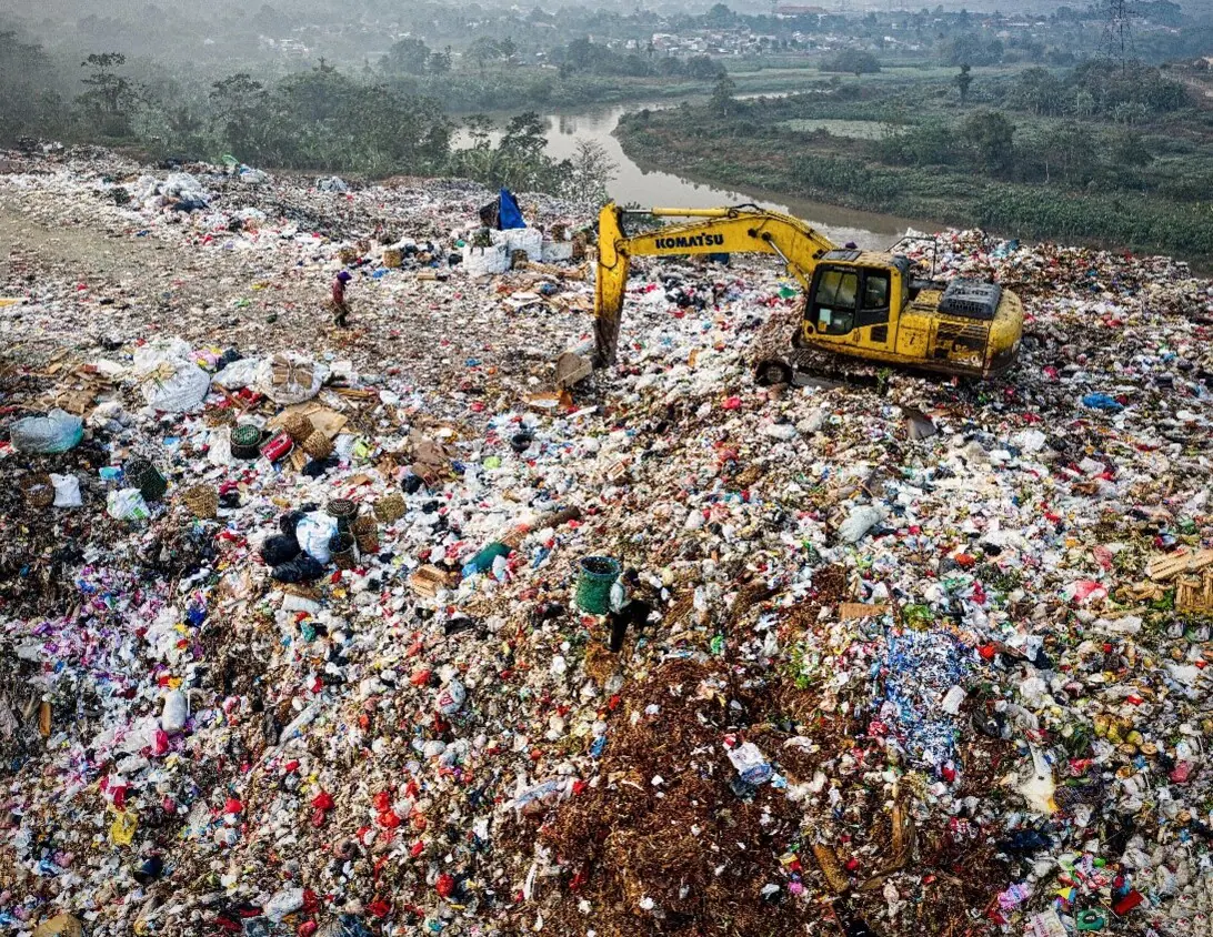An excavator at a large landfill