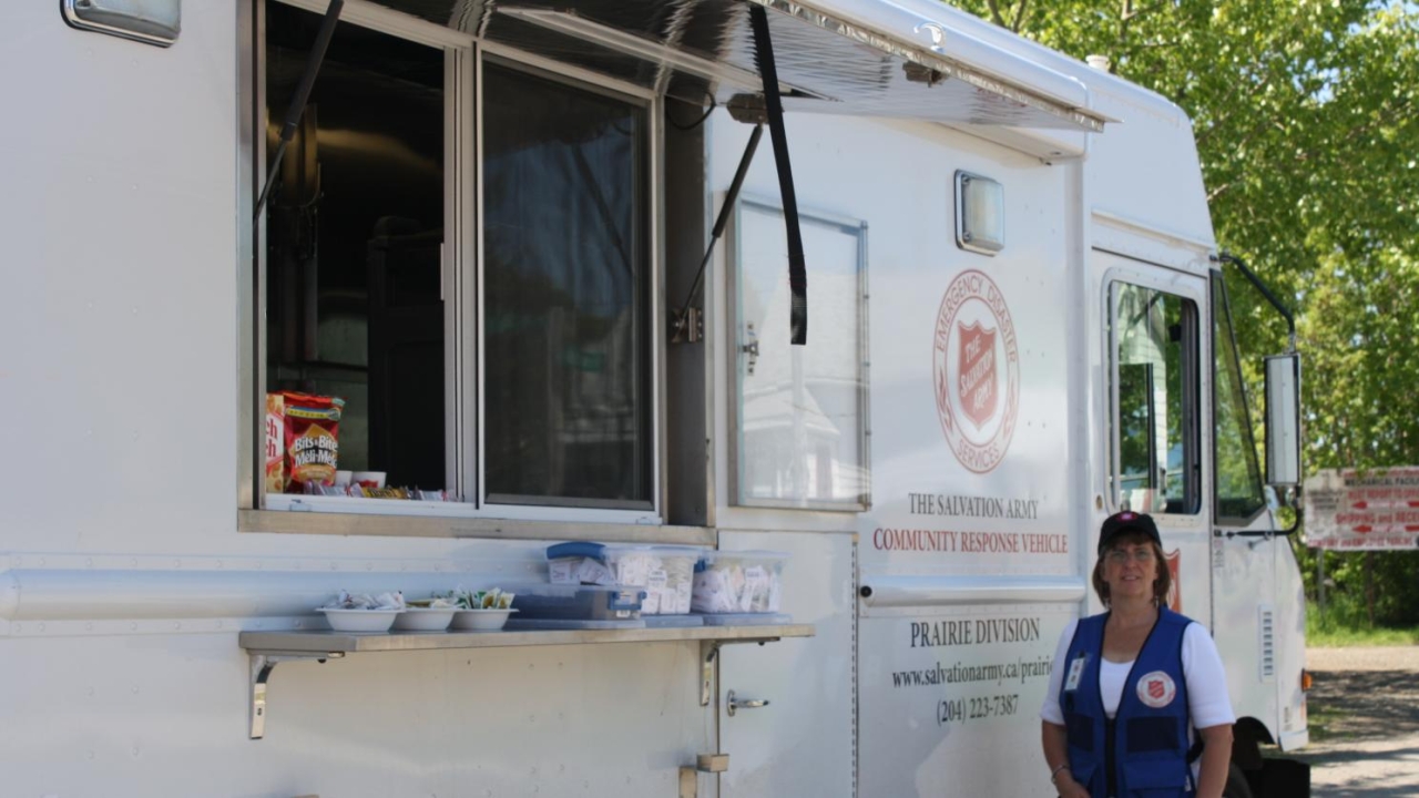 Debbie Clarke standing next to the CRU truck,  wearing a blue vest