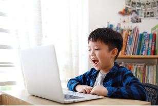 boy smiling looking at computer