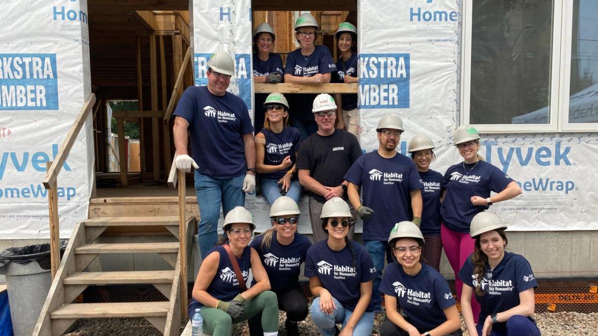 A group of volunteers posed outside a home being built