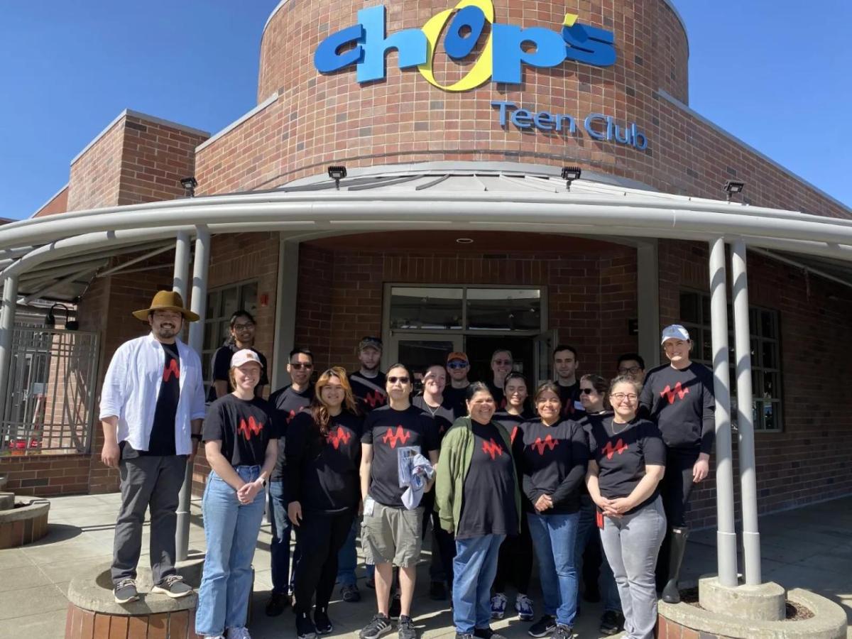 A group of volunteers in matching tshirts in front of a building "Chops tech club