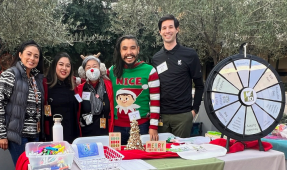 A small group behind a table decorated in festive winter items.