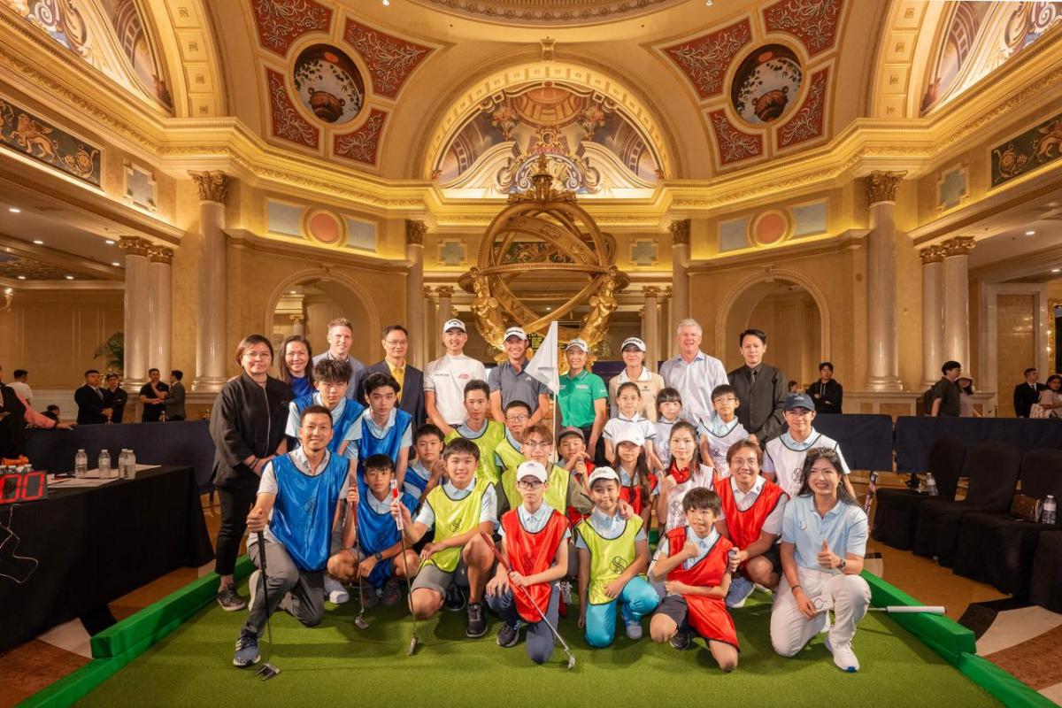 A group of adults and children posed in a group inside a fancy building.