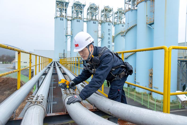 3M technician inspecting pipes at a factory. 