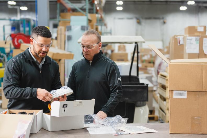 Two people inspecting a product in a delivery. 