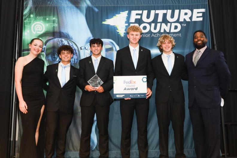6 people on stage accepting an award 