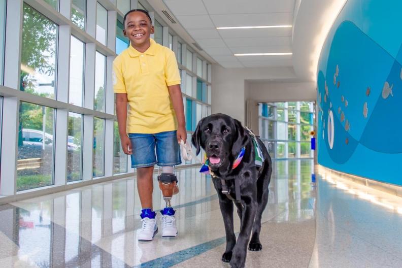 A young cancer patient with his companion dog. 