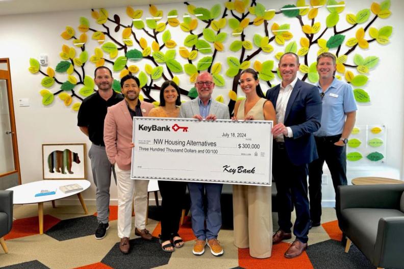 A group of people holding a large cheque  