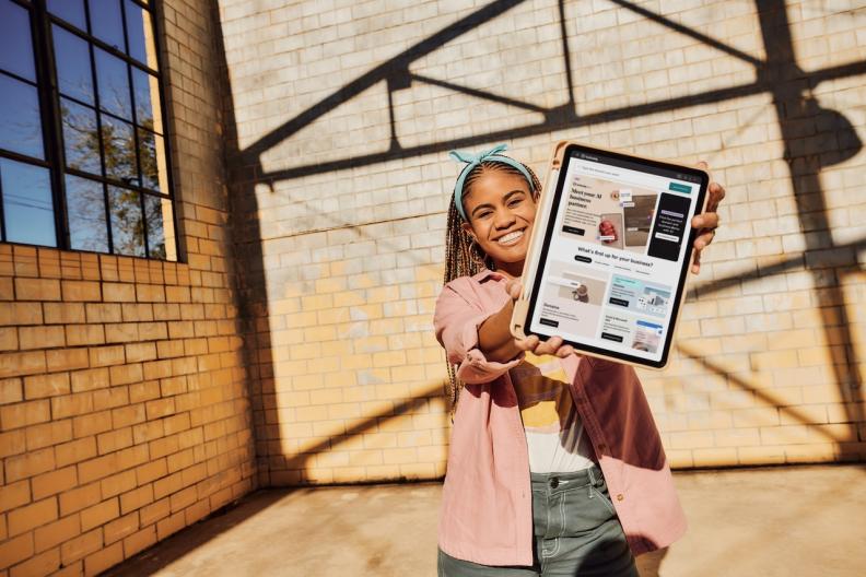 Young person holding a tablet.  