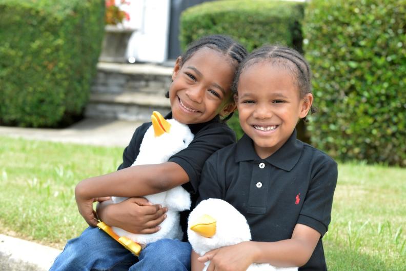 Two young boys, Saxton and Sawyer, shown each holding an Aflac duck. 