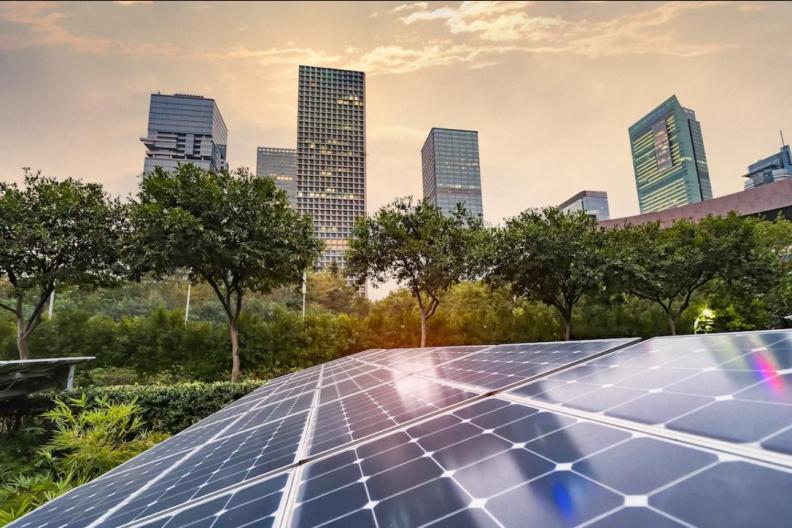 Solar panel array with a cityscape in the background. 