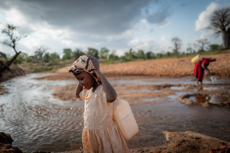 Celestine and her grandmother carrying water 