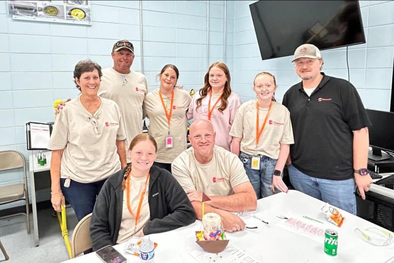 A group of 8 people posing in a cafeteria 