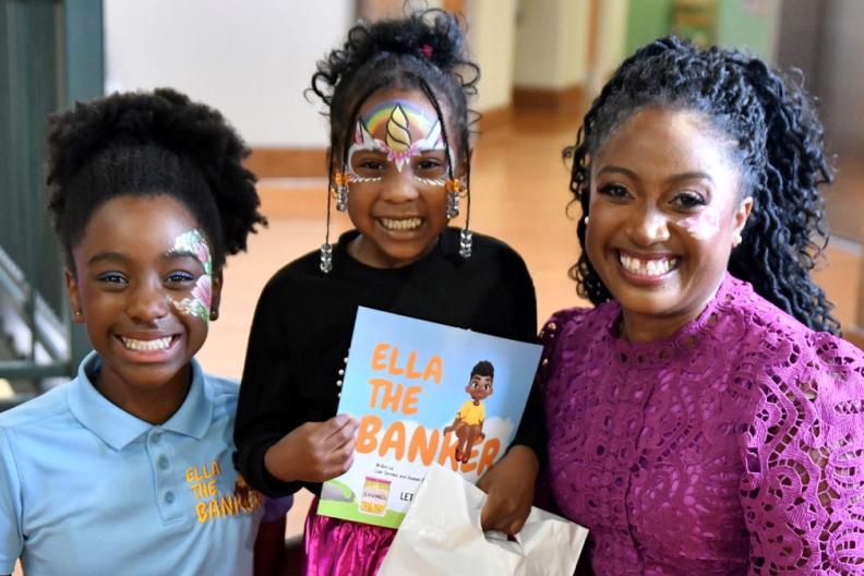 Shamim Okolloh, right, and her daughter, Ella, left, are joined by a young reader holding the book inspired by Ella and written by Ella&#039;s brother, Liam. 