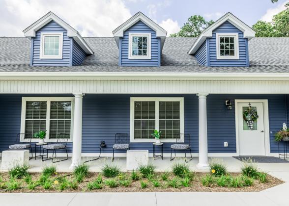 The exterior of a blue house is shown.