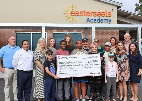 people holding up large poster of check