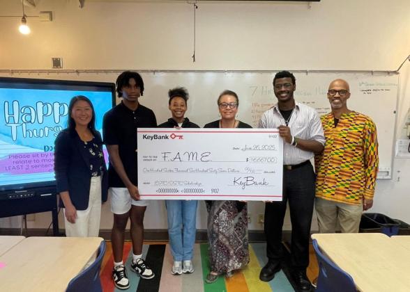 Representatives from FAME and KeyBank shown with a check for $116,670.