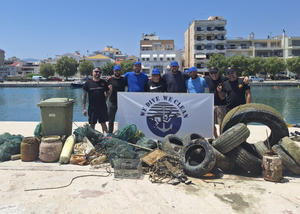 Group photo of volunteers next to the large pile of garbage they removed from the water