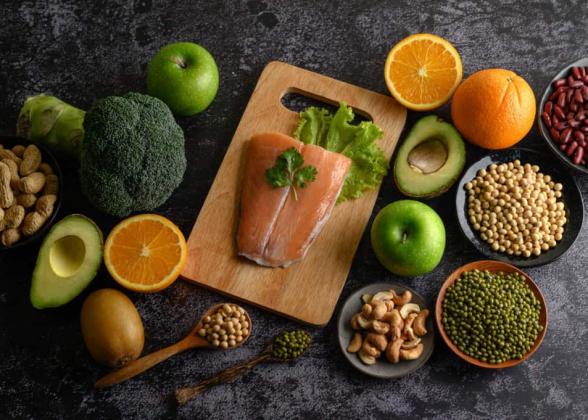 Legumes, vegetables and fruits shown on a cutting board.