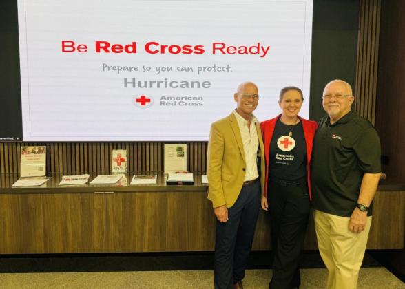 Three people standing in front of a board that reads &quot;Be Red Cross Ready&quot;