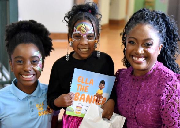 Shamim Okolloh, right, and her daughter, Ella, left, are joined by a young reader holding the book inspired by Ella and written by Ella&#039;s brother, Liam.