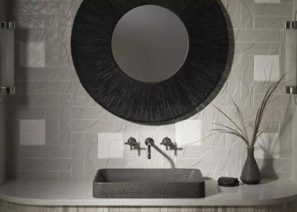 A black and white vanity, sink and mirror. A plant to one side.