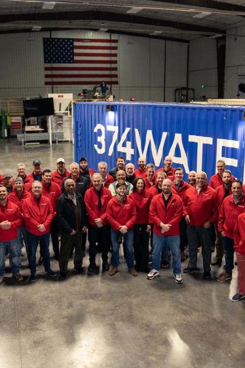 374water team in front of a reactor housed in a shipping container that can eliminate PFAS from wastewater