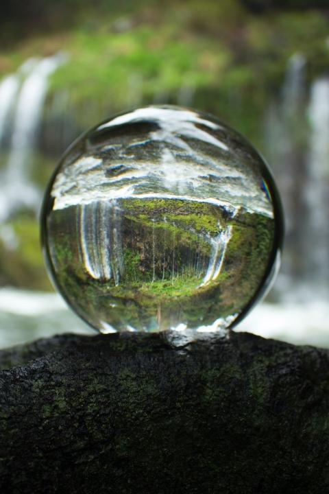 Glass ball reflecting forest and waterfall - Water Stewardship - water stewards - sustainability