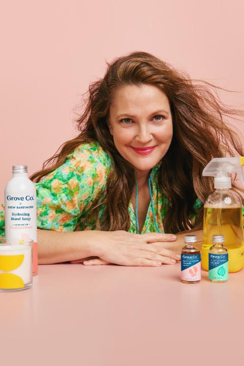 A photo of celebrity Drew Barrymore posing with her new Grove Co. product line.