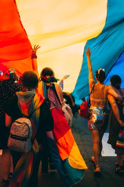 LGBTQ+ pride parade - people holding rainbow banner