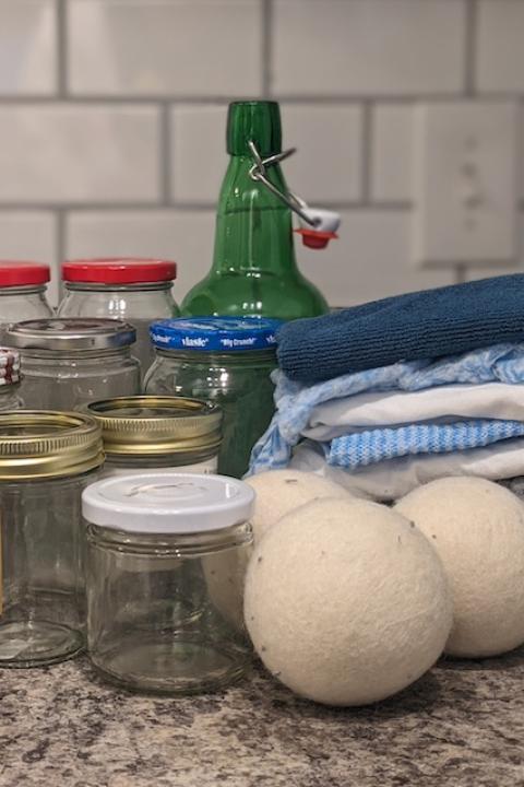 A collection of empty glass jars, kitchen towels and wool dryer balls. 