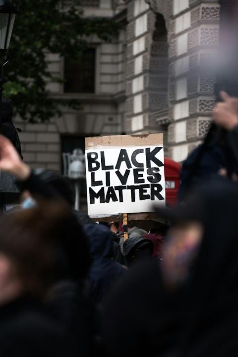demonstrator carries black lives matter sign