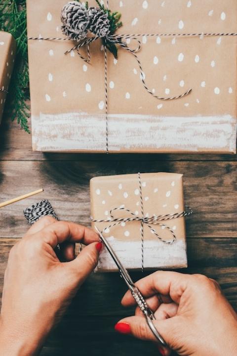 woman wrapping gifts with handmade wrapping paper - sustainable holiday gifts - sustainable holiday gift guide