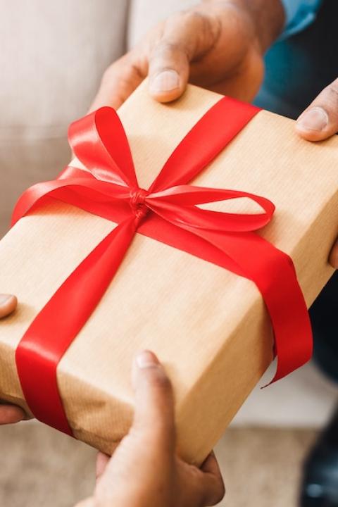 person giving a gift - GivingTuesday