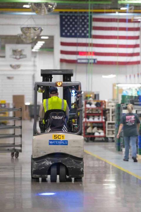 man drives forklift in warehouse - second chance hiring