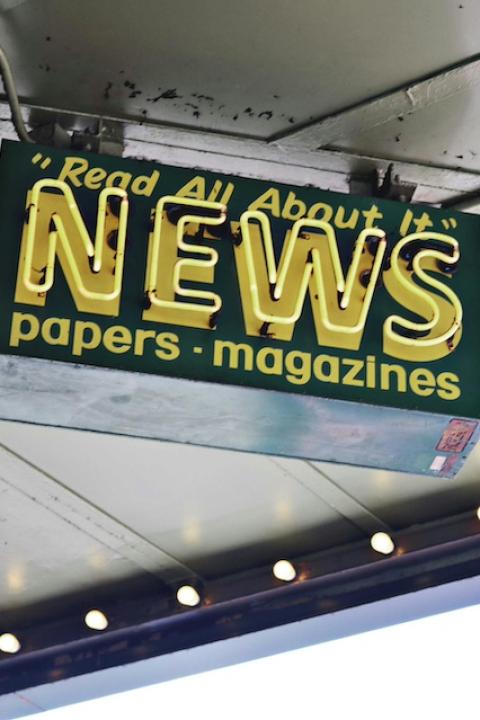 A sign reads "Read all about it. News. Papers. Magazines." 