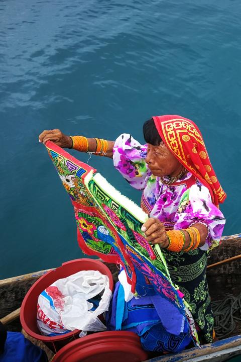 A Guna Yala woman in a canoe displaying her wares.