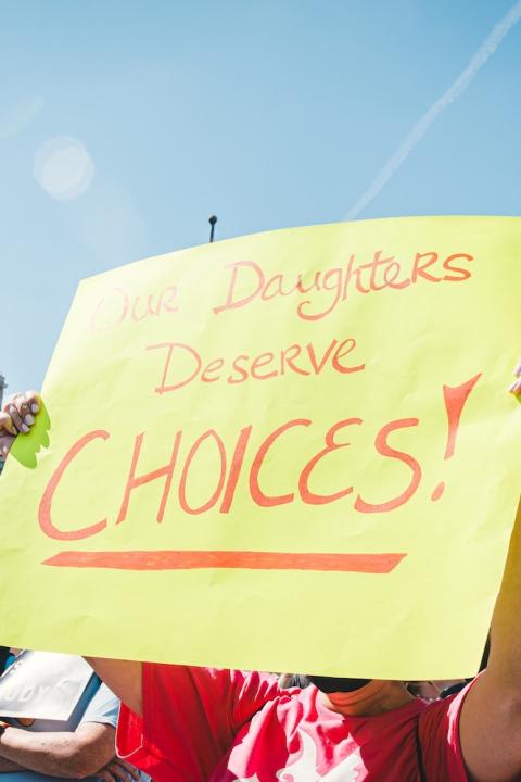 protesters hold signs at a rally for abortion rights