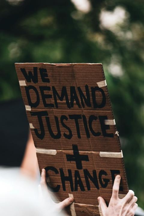A protester holds a sign that reads "We demand justice and change."