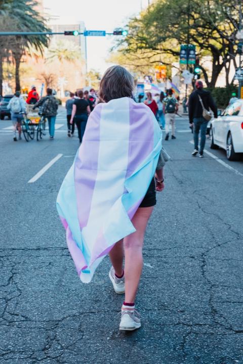 trans rights demonstrator wears trans flag