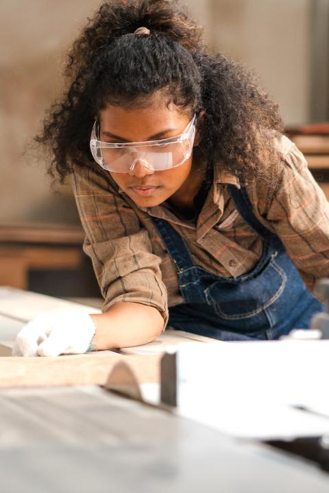 woman carpenter measuring wood - workforce training for skilled trades