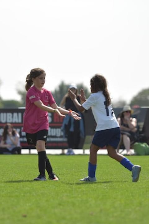 young girls high five during soccer game - youth sports