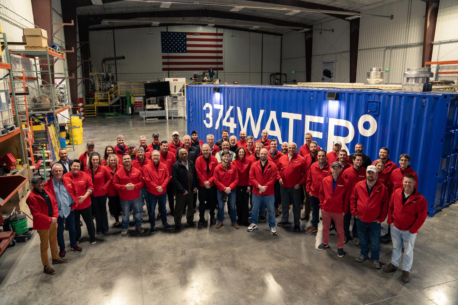 374water team in front of a reactor housed in a shipping container that can eliminate PFAS from wastewater