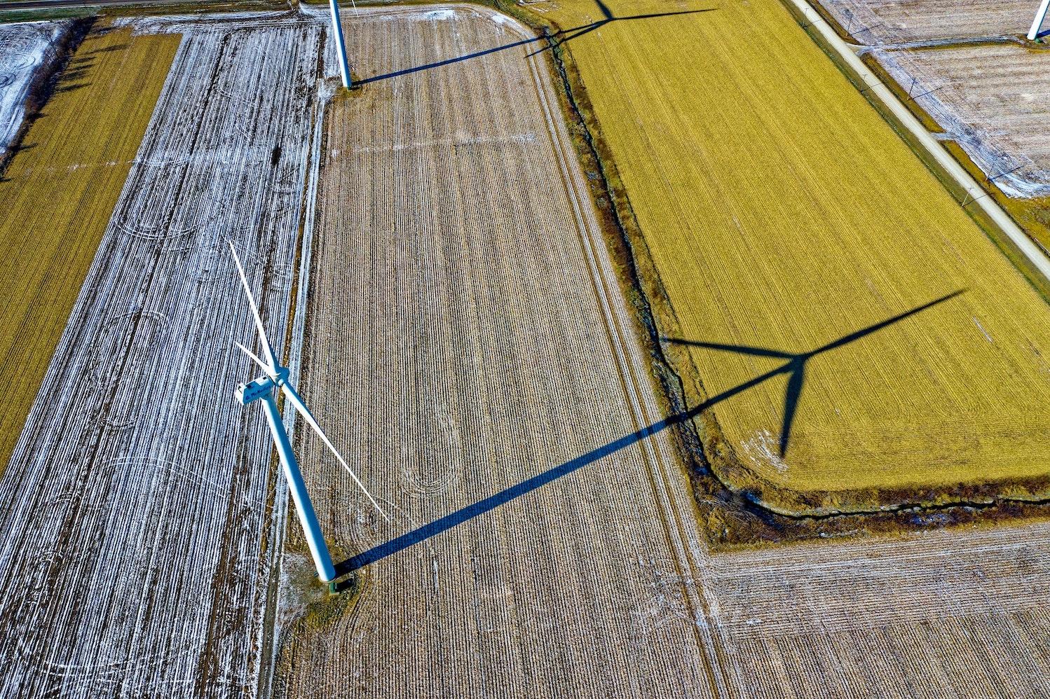 Aerial view of farms with wind turbines and a country road - engaging with suppliers on Scope 3