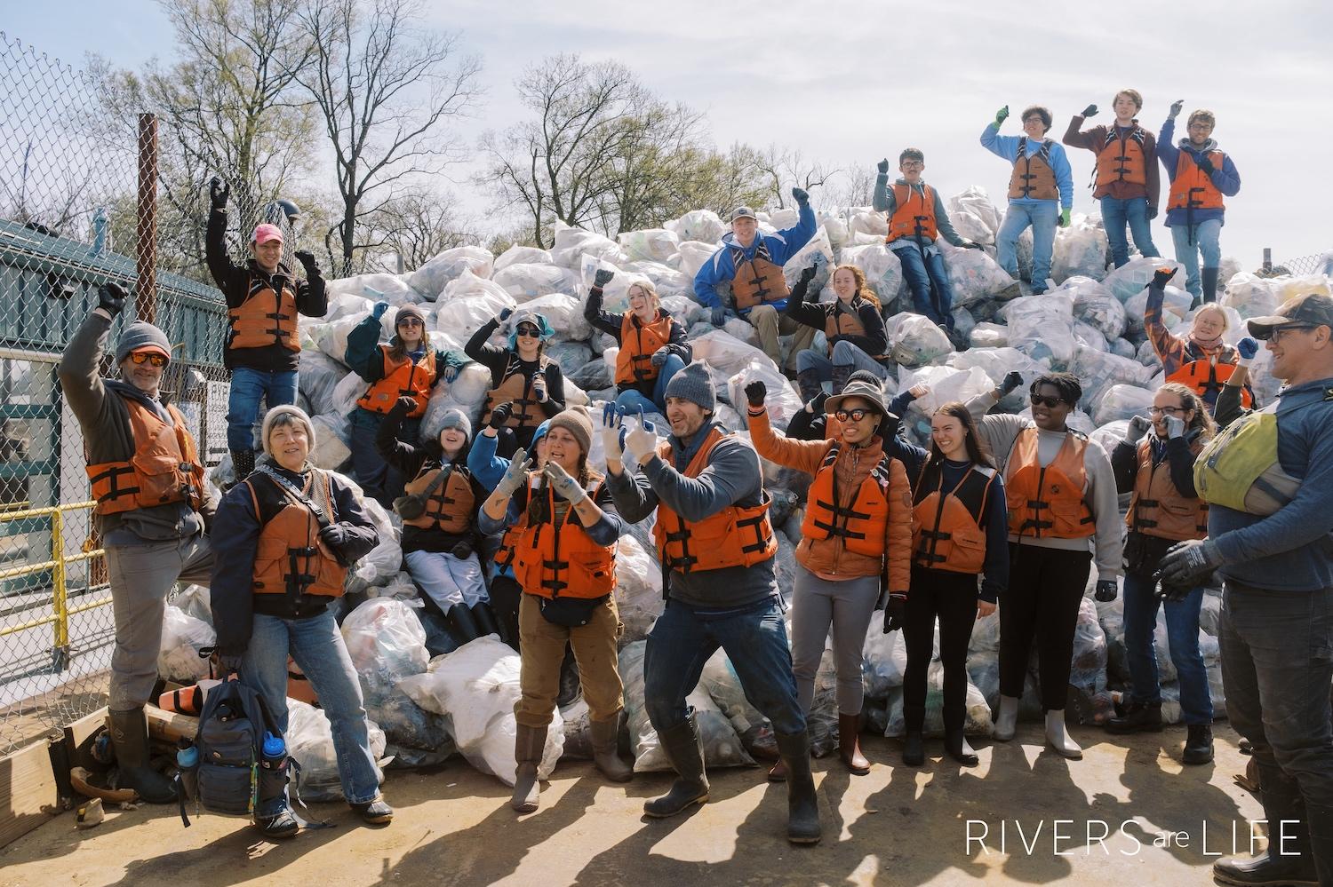 Members of the Alternative Spring Break Program pose with a pile of bagged trash.